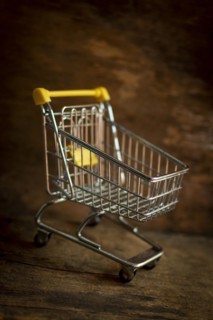 Empty metal miniature shopping cart on a brown background
