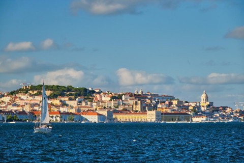 View of Lisbon over Tagus river from Almada with yachts tourist boats on sunset