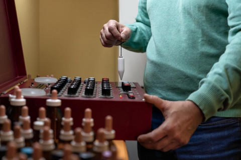 Adult man performing analysis with a radionic machine