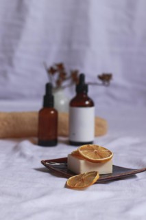 Essential oil bottles and organic vegan soap with dried lemon slices