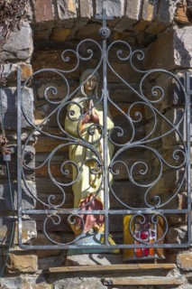 Figure of the Virgin Mary behind a barred niche