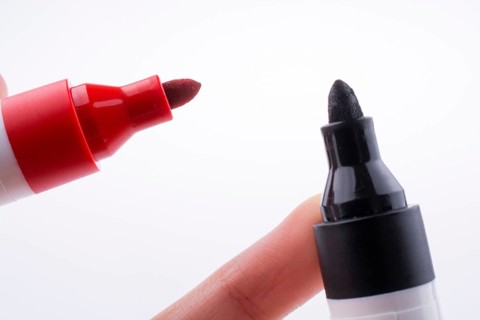 Hand holding Color markers face to face on a white background