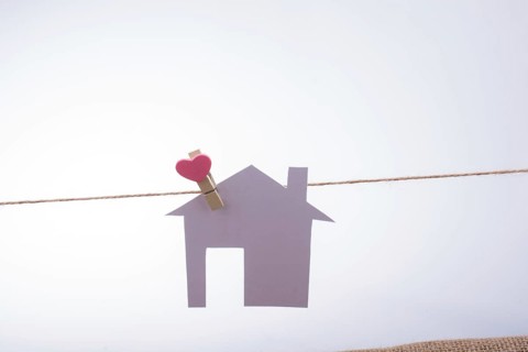 Little paper house attached to a string with a heart clip