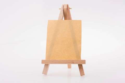 Brown color notepaper on a painting tripod on white background