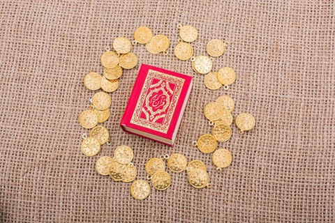 Fake gold coins around the Islamic Holy Book Quran