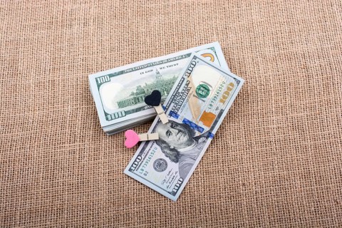 Heart icon bundle of US dollar placed on a linen canvas