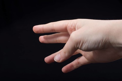 Five fingers of a child hand partly seen in black background