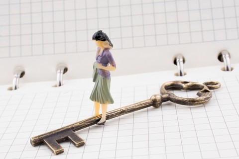 Human figure near a key on a white spiral notebook