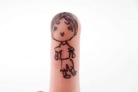 Child figure drawn on a finger tip with black color