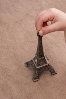 Child holding the little model of Eiffel Tower in hand