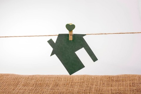 Little paper house attached to a string with a heart clip