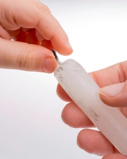 White candle stick in hand on a white background