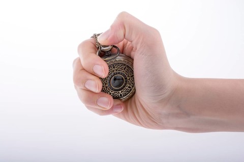 Hand holding a retro styled pocket watch in hand