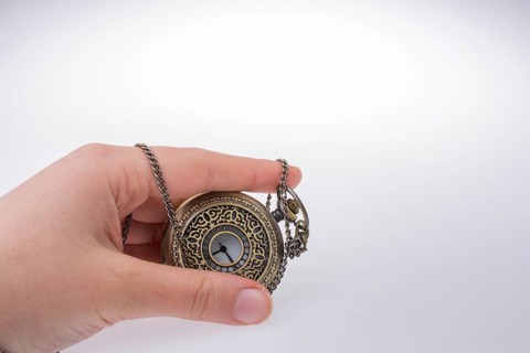 Retro style pocket watch in hand on white background