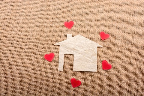 Heart shape around the paper house with a canvas background