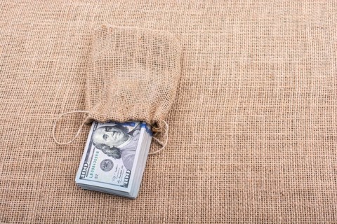 Banknote bundle of US dollarin a sack on a canvas