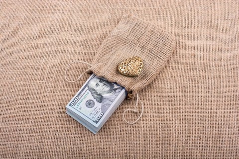 Heart icon bundle of US dollar placed on a linen canvas