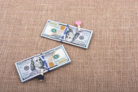 Heart icon bundle of US dollar placed on a linen canvas