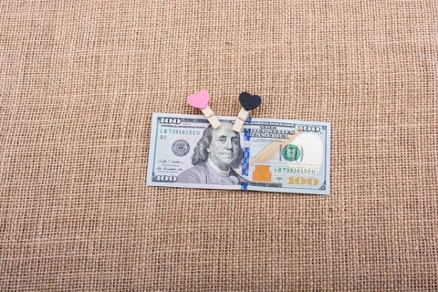 Heart icon bundle of US dollar placed on a linen canvas