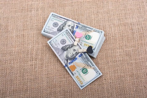 Heart icon bundle of US dollar placed on a linen canvas