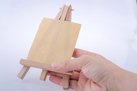 Brown color notepaper on a painting tripod in hand