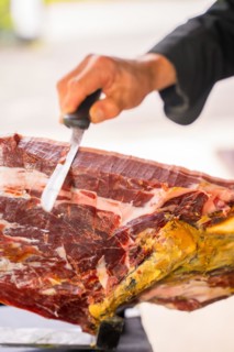 Detail of a man cutting Iberian ham at a wedding or event