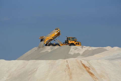 Dump truck unloading salt at a salt mine for salt extraction