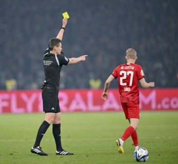 Referee Daniel Siebert shows Konrad Laimer