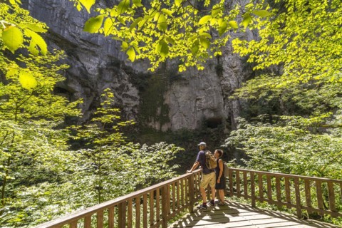 Tourists at the Creux Billard rock cauldron at the Source du Lison near Nans-sous-Sainte-Anne