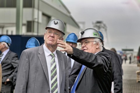 Minister President Winfried Kretschmann with Martin Herrenknecht - both wearing safety helmets - during a visit to Herrenknecht AG