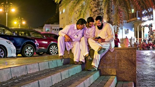 Three men look at mobile phone