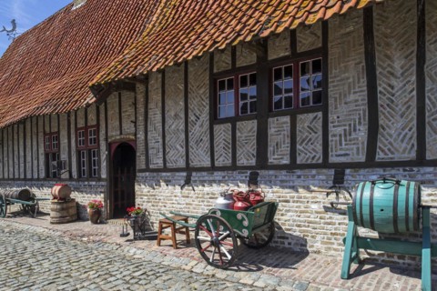 Antique handcart with milk churns and vintage barrel-type butter churn at the open air museum Bachten de Kupe