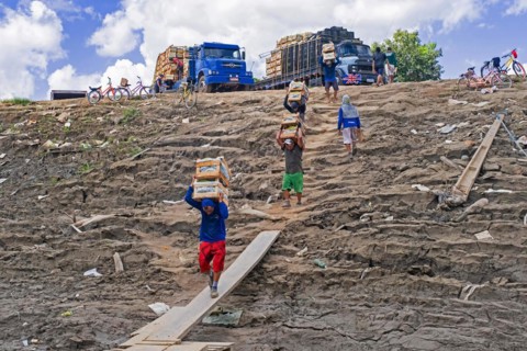 Manual labourers loading bananas from trucks to inland passenger and cargo vessel on the Amazon river at Porto Velho