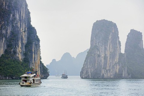 Tourist boats and limestone monolithic islands in Ha Long Bay