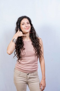 Young woman making phone gesture with fingers. Young girl making phone gesture isolated