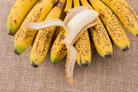 Bunch of yellow freckled bananas on a canvas texture