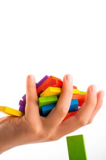 Falling colorful domino onto a hand