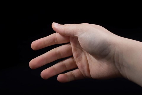 Five fingers of a child hand partly seen in black background
