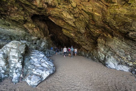 Tourists walk the fabled Merlins Cave