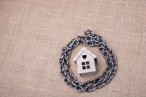 Metal chair around a model house on a linen canvas