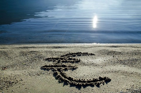Euro Symbol on the Sand Beach with Sunlight