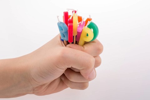 Hand holding letters made of candles on sticks