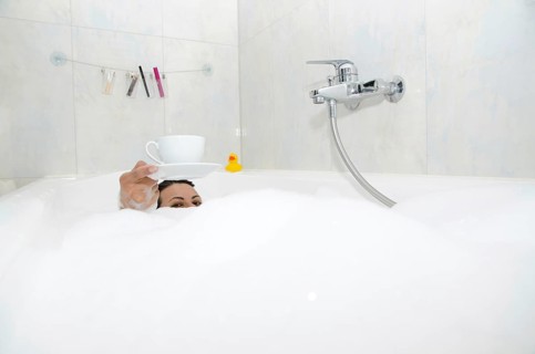 Woman Drinking a Coffee in the Bathtub with Foam