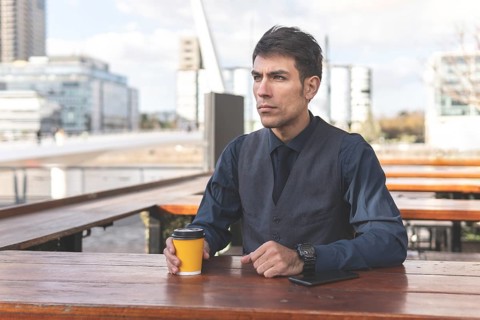 Businessman sitting at an outdoor bar having a coffee