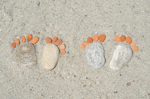 Couple of Footprints Made of Stones in the Sand