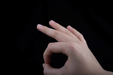 Hand gesturing sign ok okay agree on black background