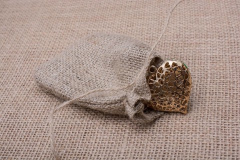 Heart shaped gold color metal object out of sack