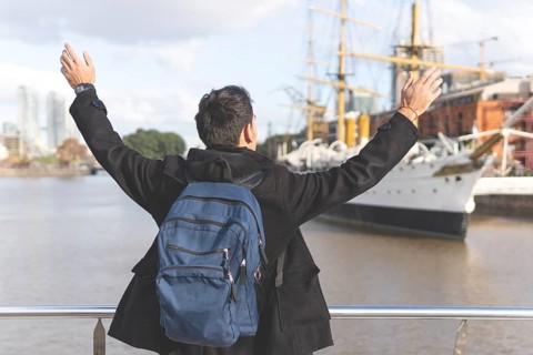 Back view of a tourist posing in front of a boat in Puerto Madero