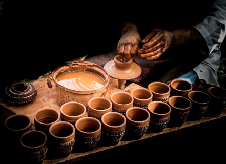 Potter`s hands shaping up the clay of the pot