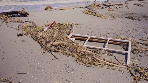 Window frame of house lies on sand
